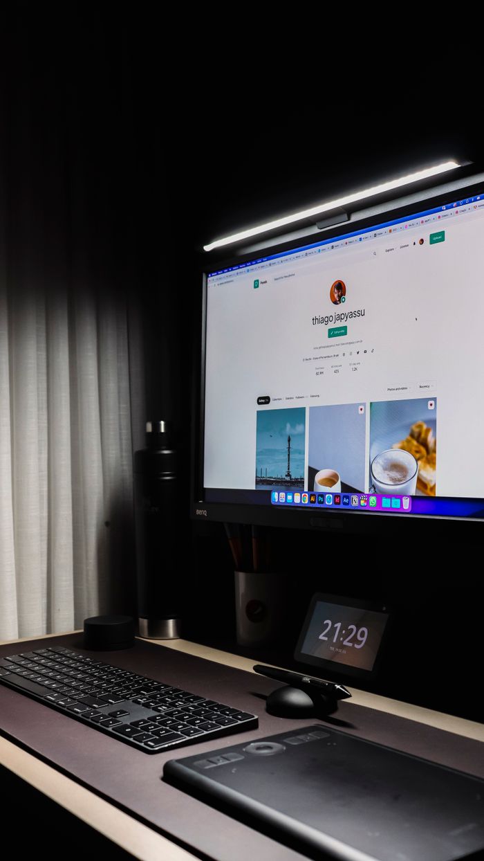 A neat and modern workspace showcasing a monitor, keyboard, and technology accessories.